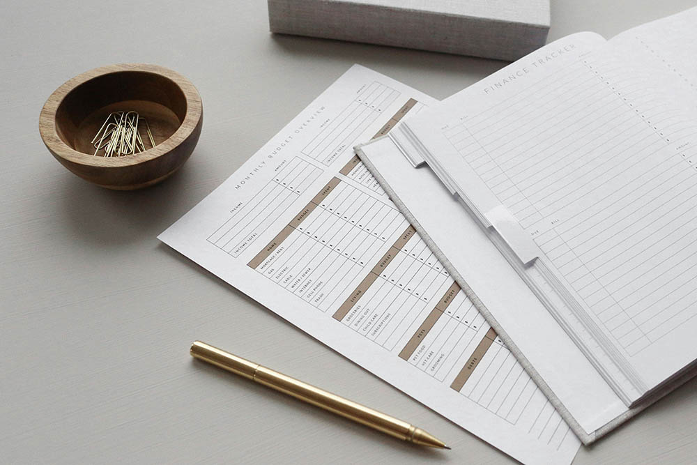 A photo showing monthly statements printed on a desk with paper clips and a pen nearby.